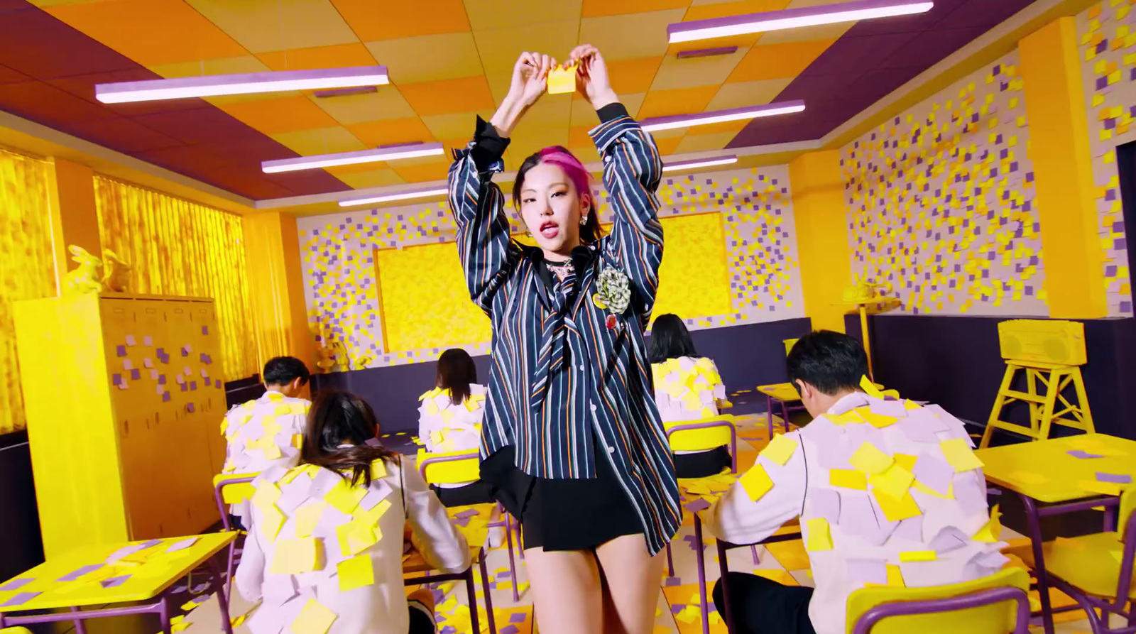 a woman standing in front of a room filled with yellow chairs