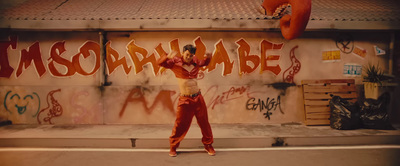 a man standing in front of a graffiti covered wall