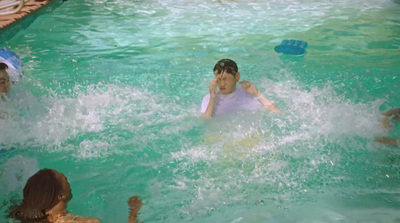 a group of people in a pool playing with a frisbee