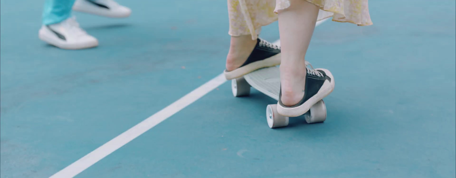 a person riding a skateboard on a tennis court