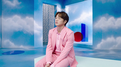 a man in a pink suit sitting on a table