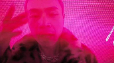 a man making a weird face in front of a pink background