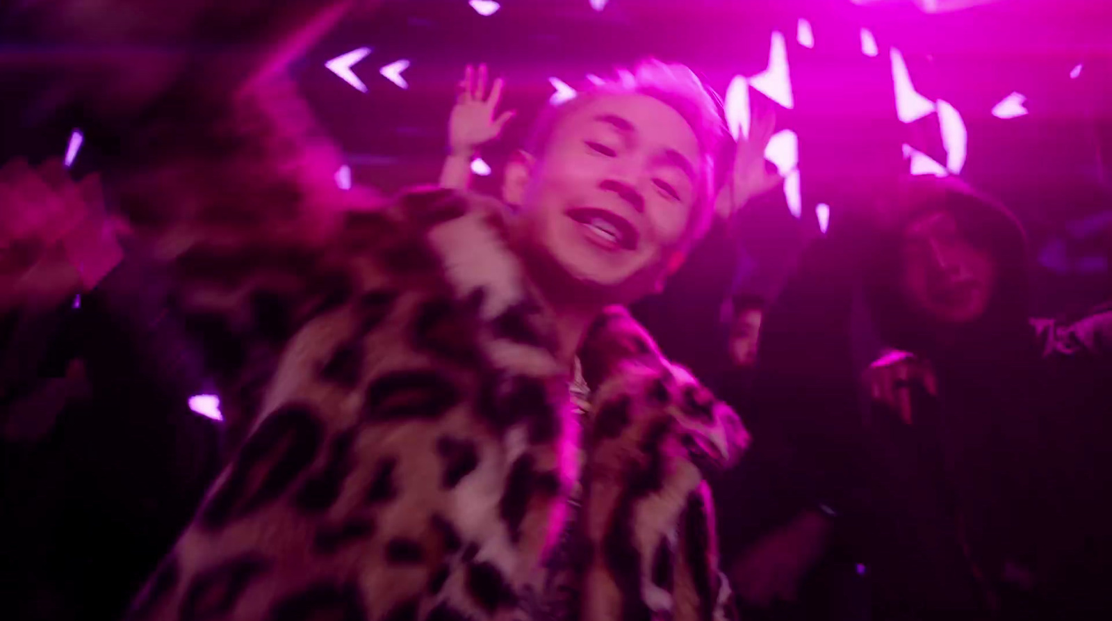 a woman in a leopard print coat dancing