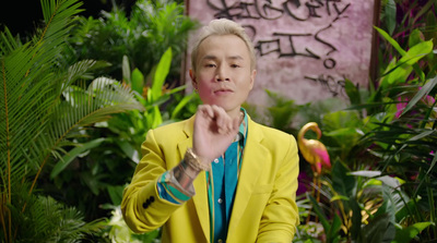 a man in a yellow suit standing in front of plants