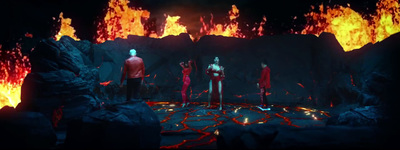 a group of people standing on top of a lava covered ground