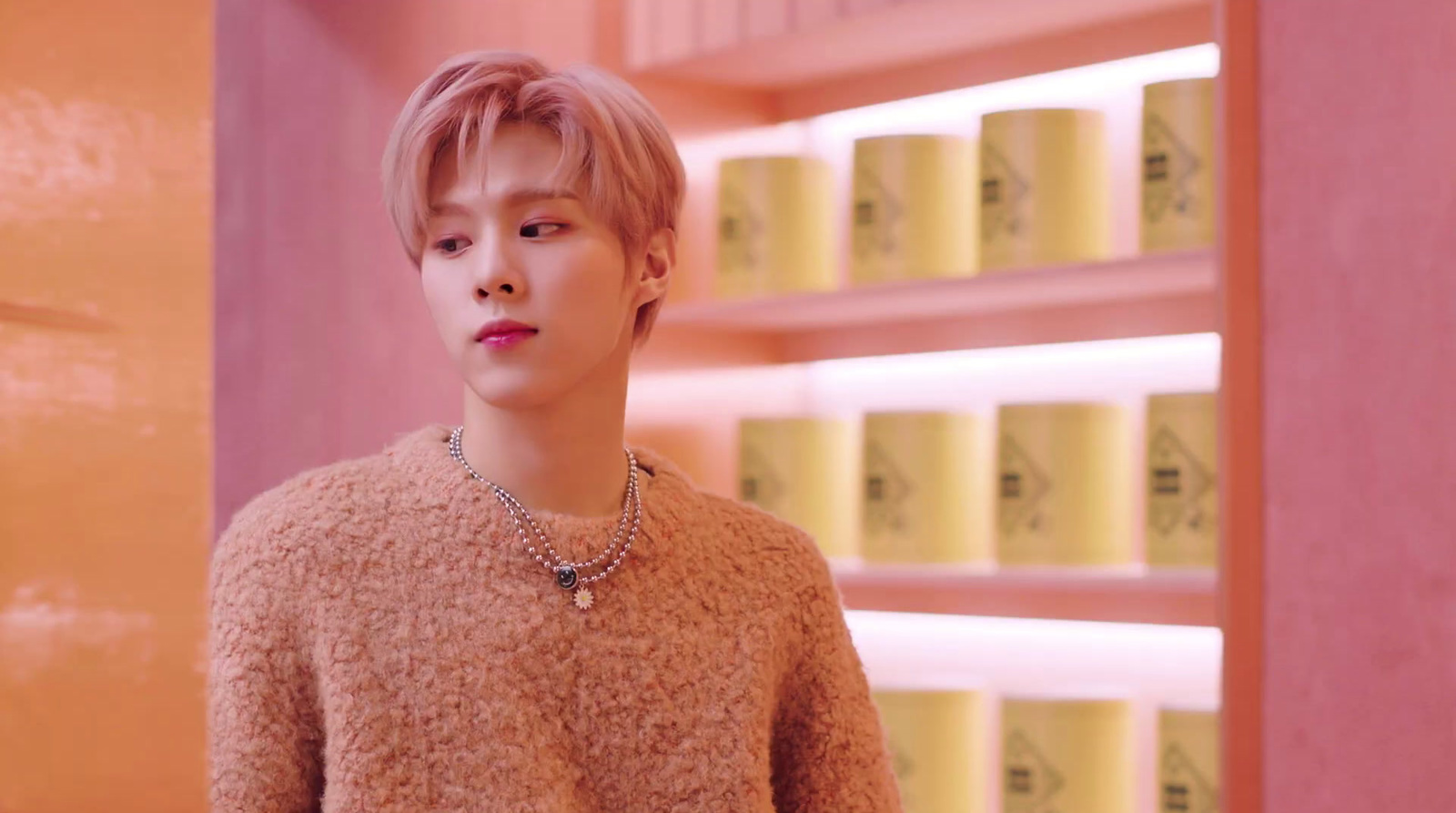 a young man standing in front of a shelf