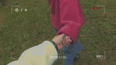 a person holding the hand of a child in a field