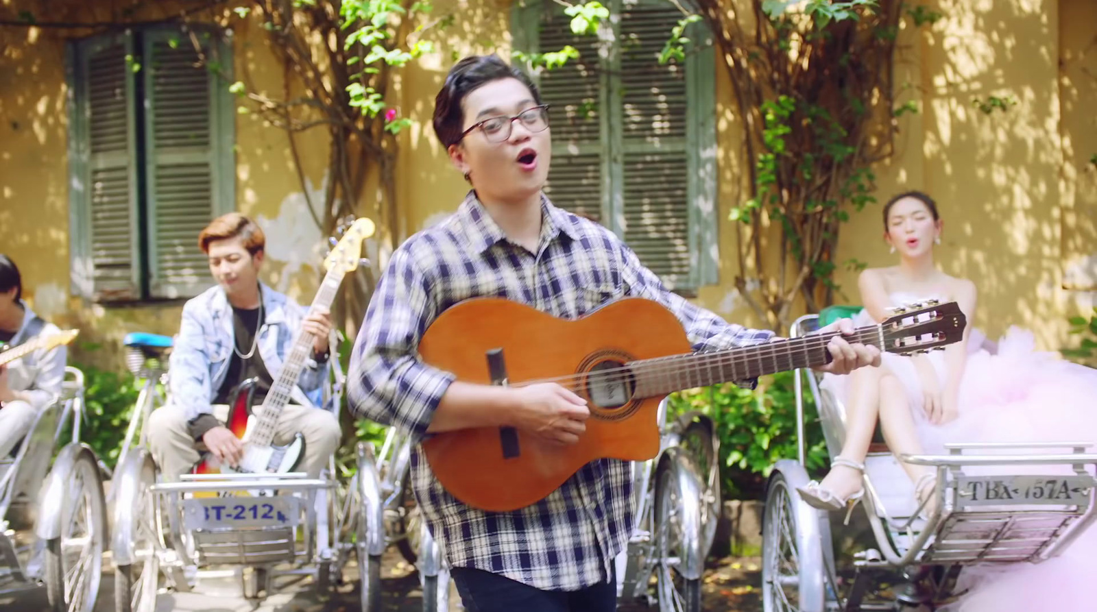 a man playing a guitar in front of a group of people