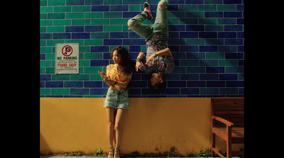 a couple of people standing next to a wall