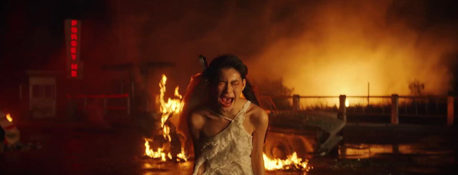 a woman standing in front of a fire with her mouth open