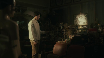 a man standing in a living room next to a chair