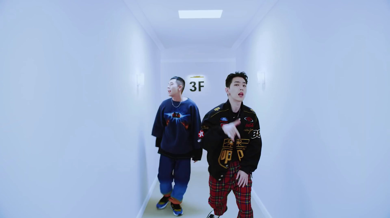 two young men are walking down a hallway