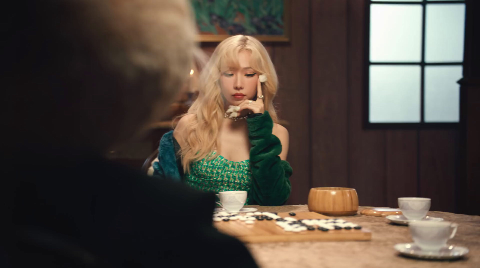 a woman in a green dress sitting at a table