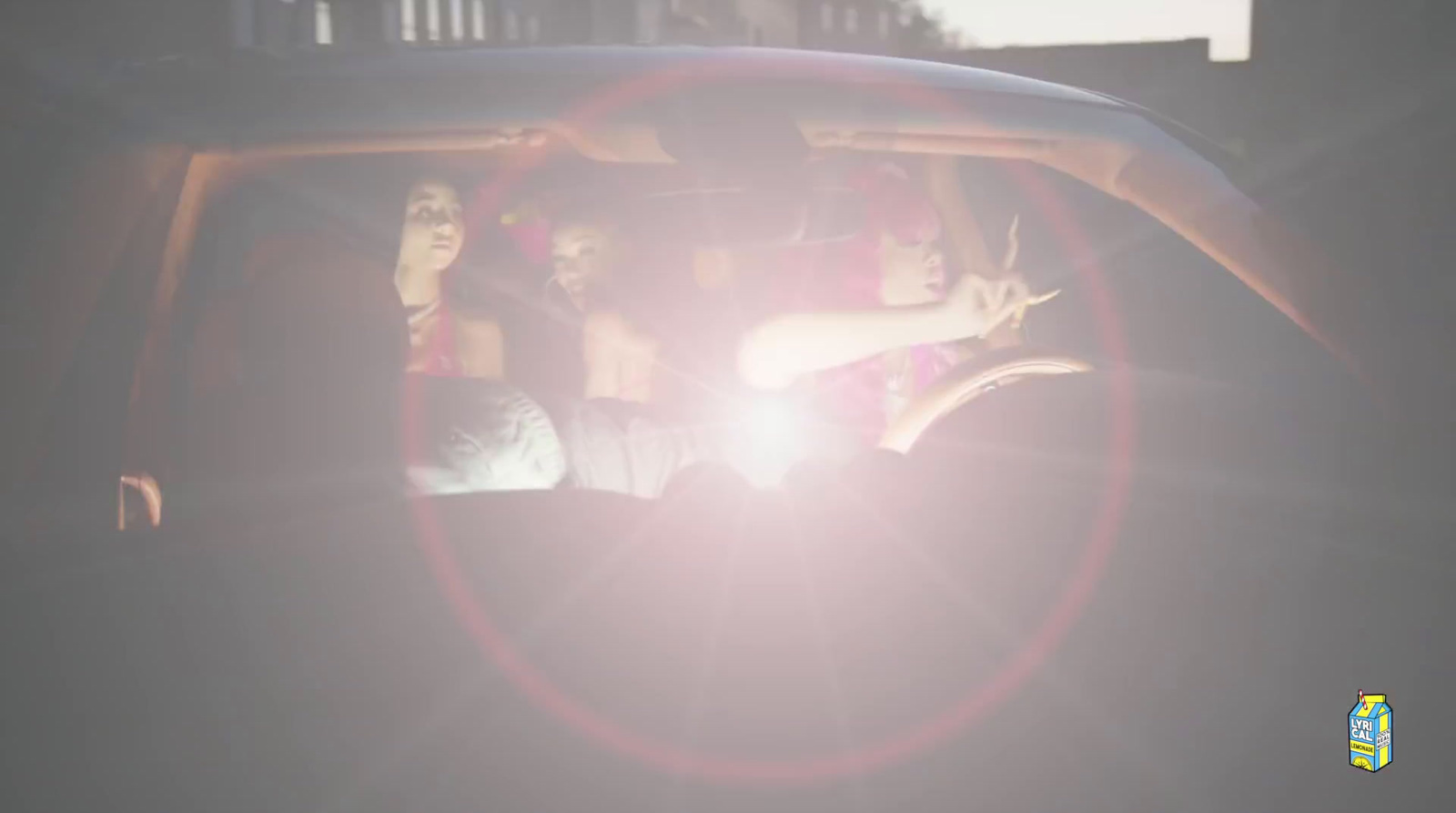 a group of people sitting in a car in the sun