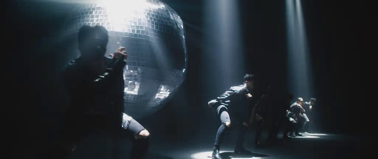 a group of people standing around a disco ball