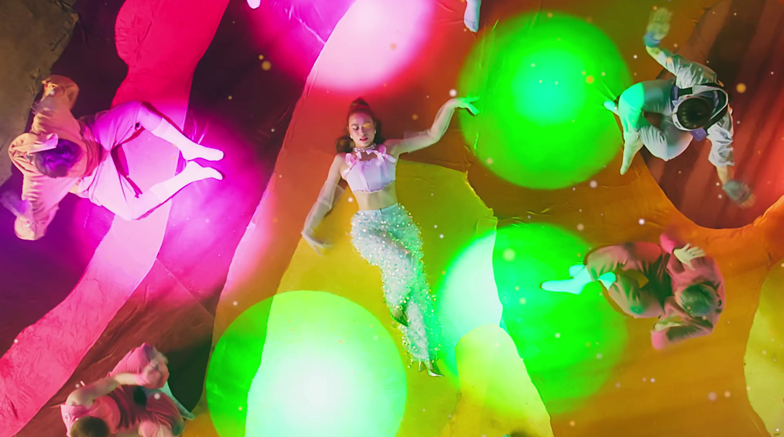 a group of people standing around a colorful ball