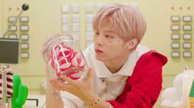 a person holding a jar with candy in it