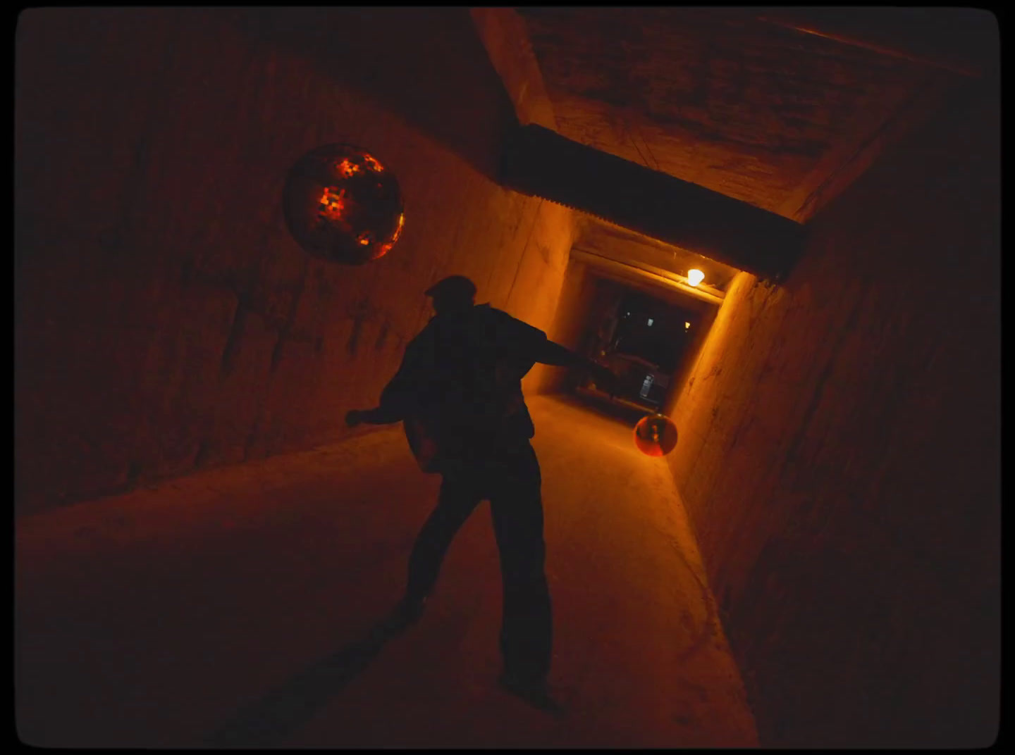 a man standing in a dark tunnel with a light on