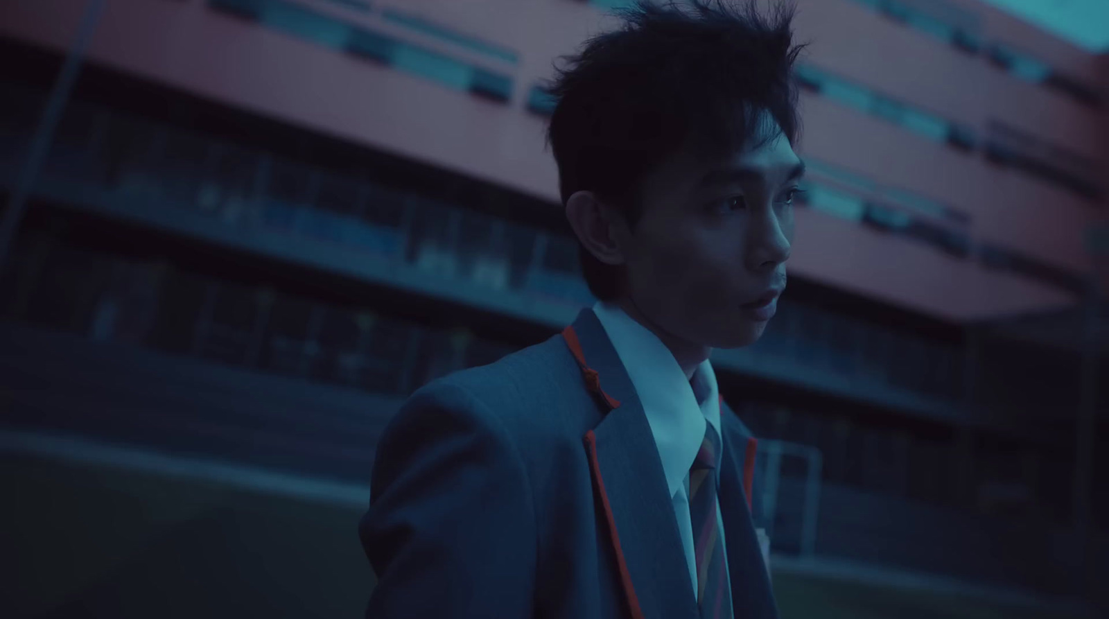 a man in a suit and tie standing in front of a building