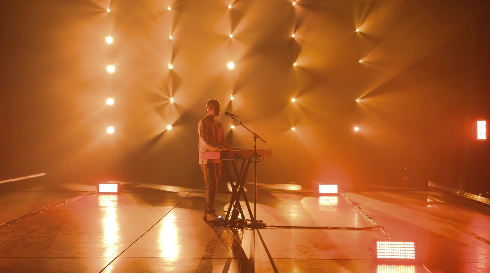 a man standing in front of a microphone on a stage