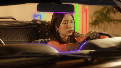 a woman sitting in a car with a steering wheel