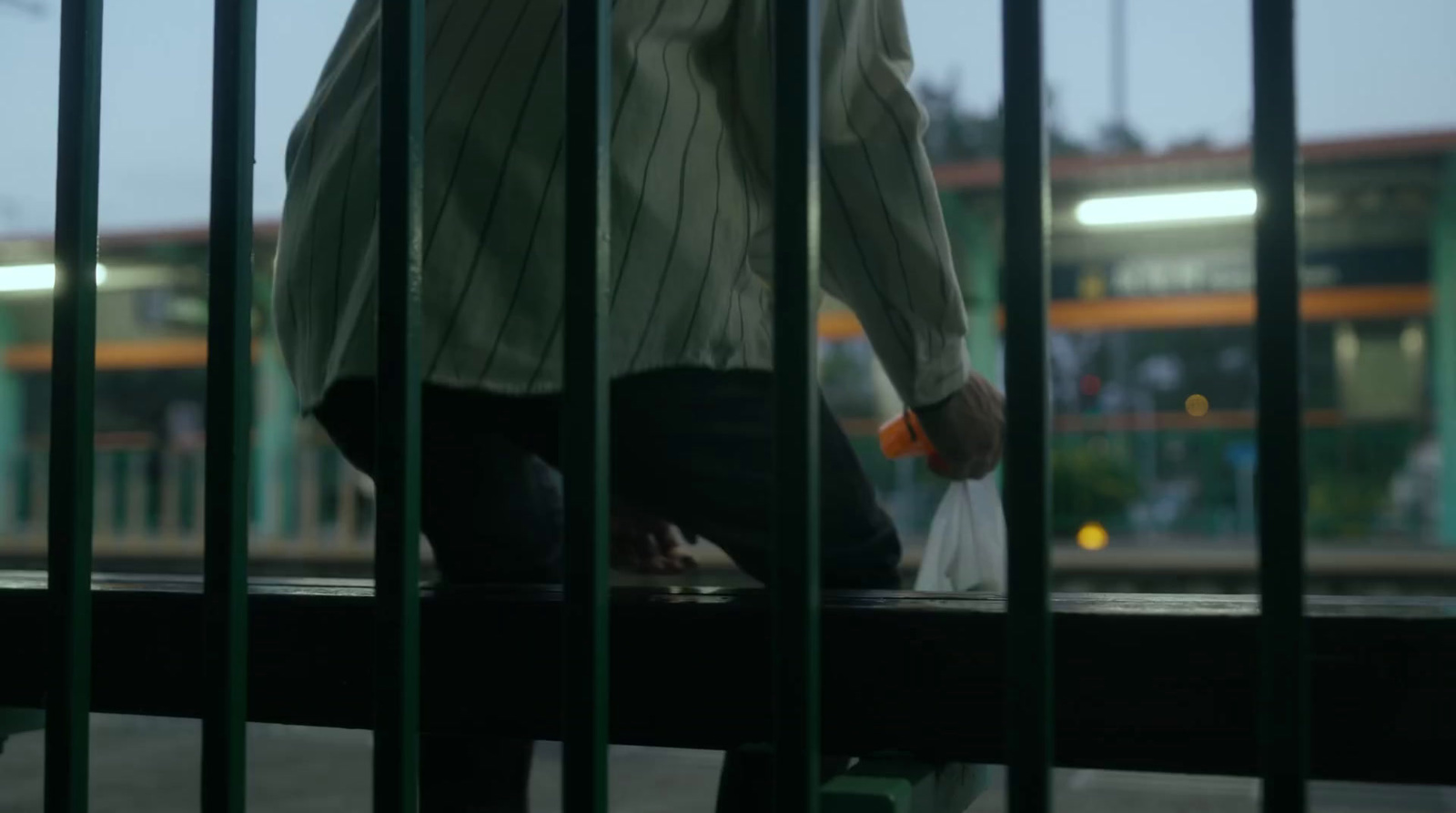 a man riding a skateboard through a metal fence