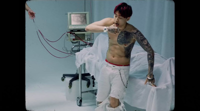 a man with tattoos standing in a hospital room