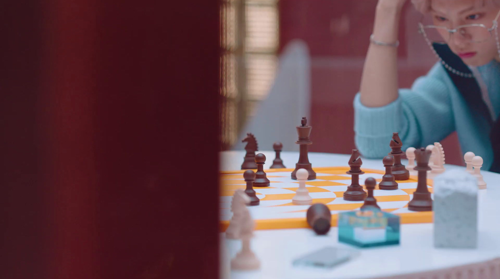 a woman playing a game of chess on a table