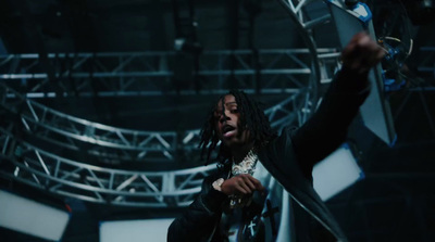 a man with dreadlocks standing in front of a stage