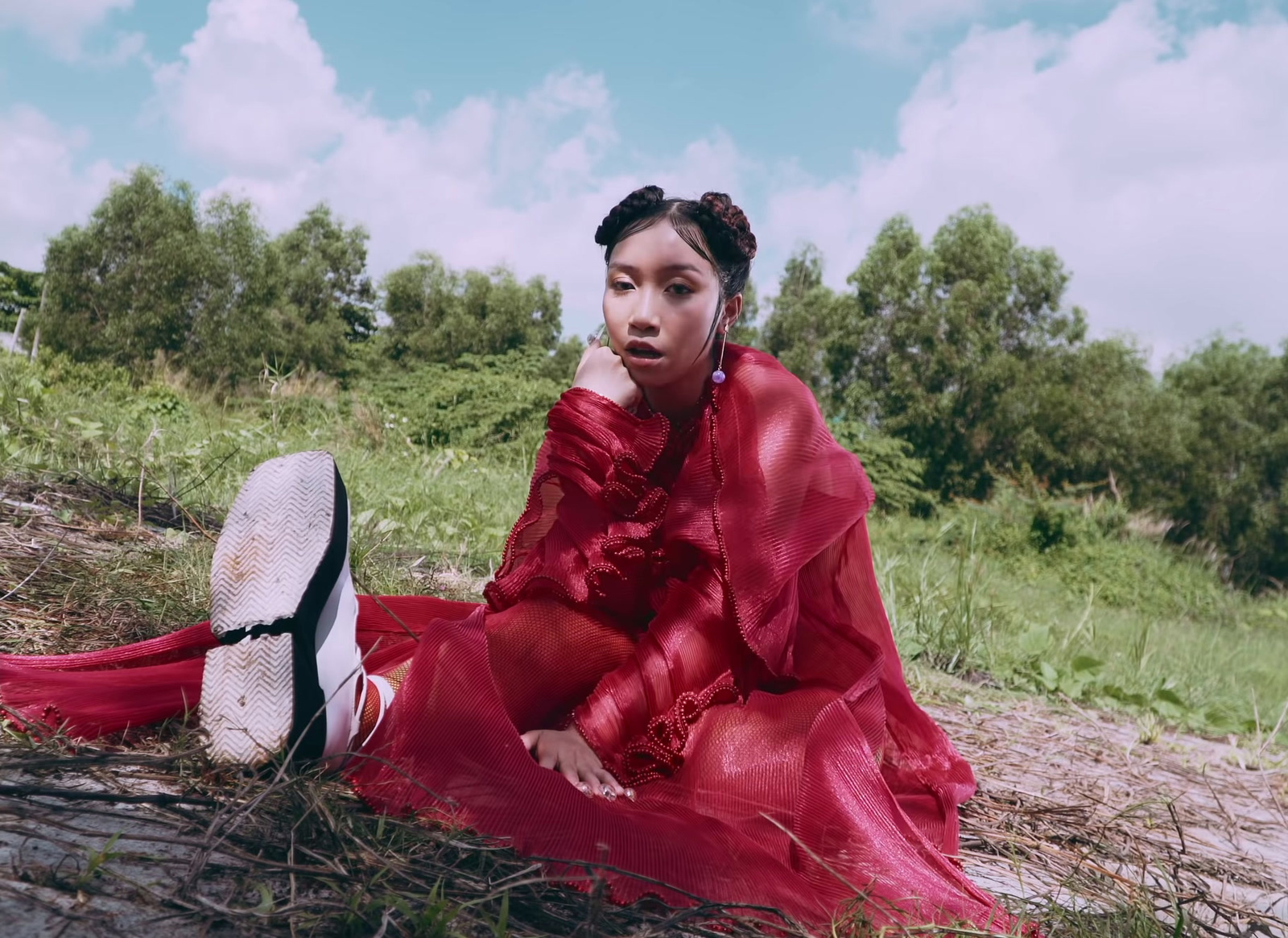 a woman in a red dress sitting on the ground