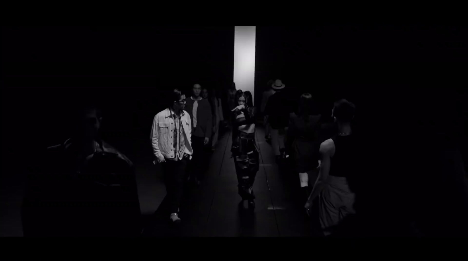 a group of people walking down a dark hallway