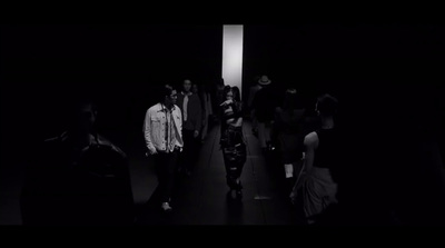 a group of people walking down a dark hallway