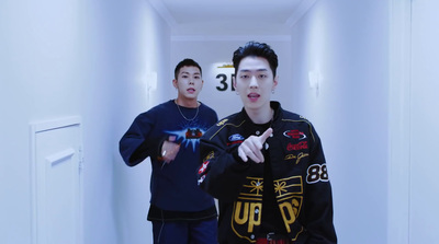 two young men are standing in a hallway