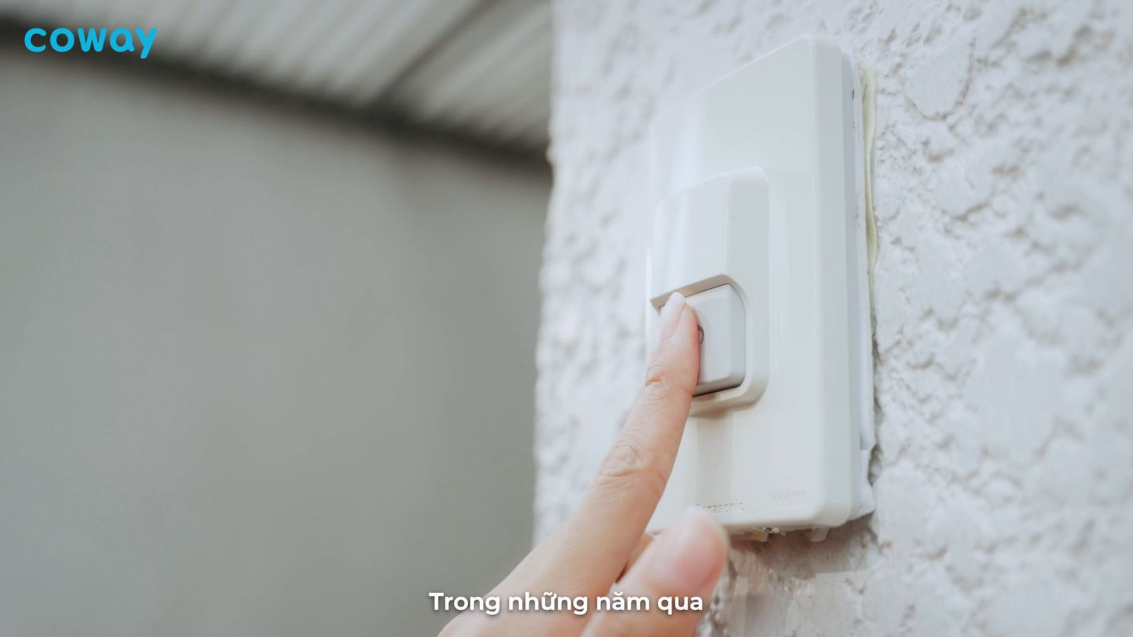 a person turning on a light switch on a wall