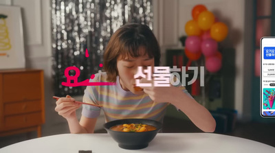 a woman eating a bowl of food with a cell phone in front of her