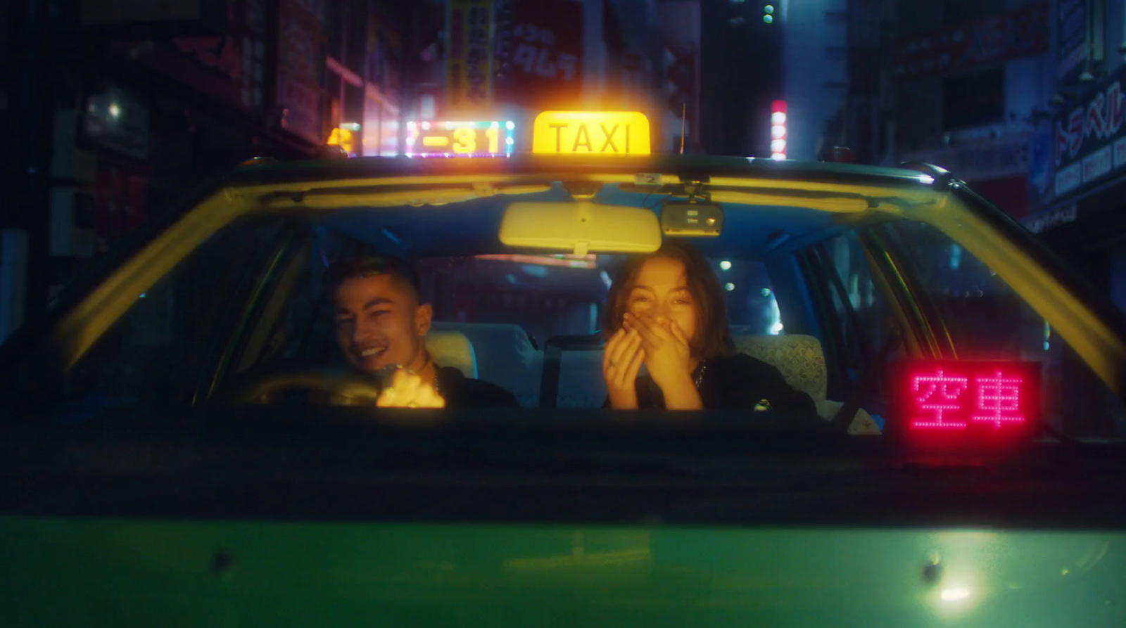 two people sitting in a taxi at night