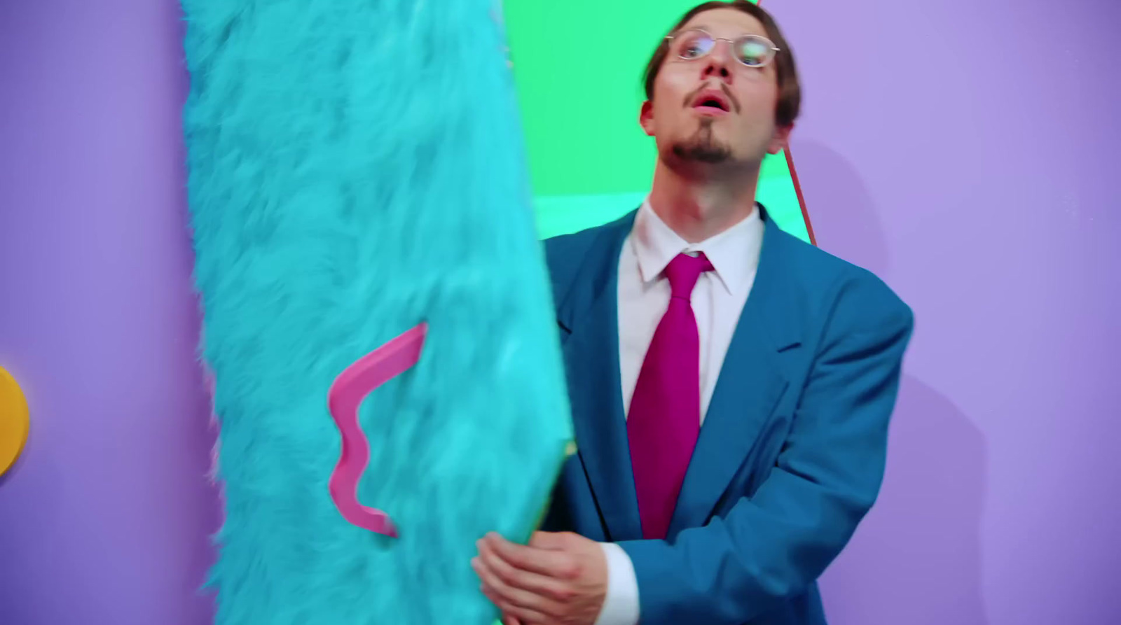 a man in a suit and tie holding a surfboard