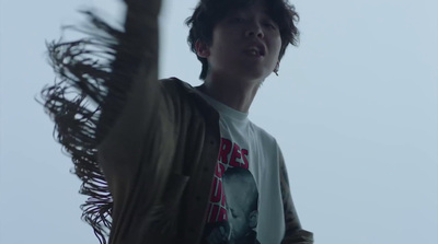 a young man standing next to a tall palm tree