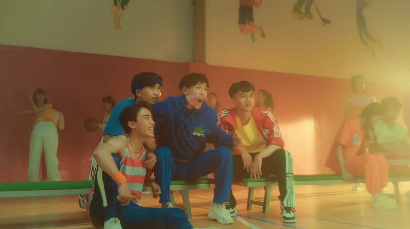 a group of young men sitting next to each other on a basketball court