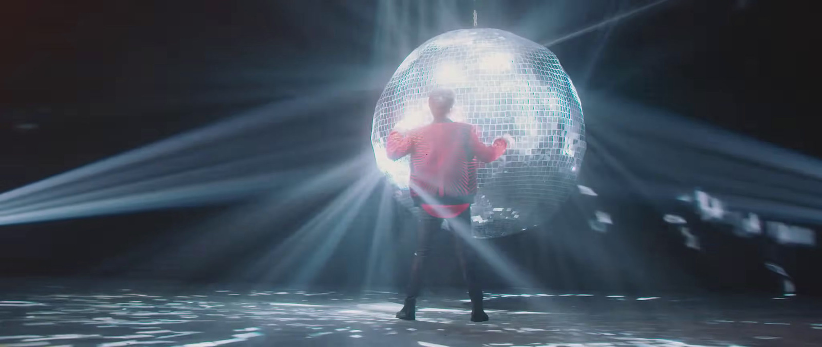 a man standing in front of a disco ball