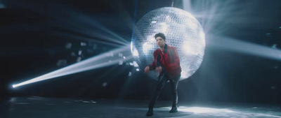 a man standing in front of a disco ball