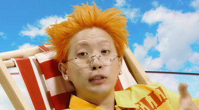 a man with orange hair sitting in a chair