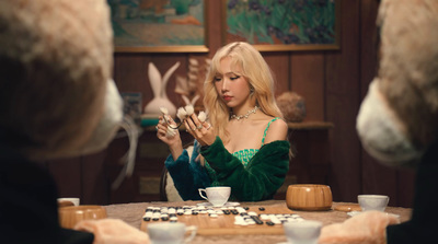 a woman sitting at a table in front of a cake