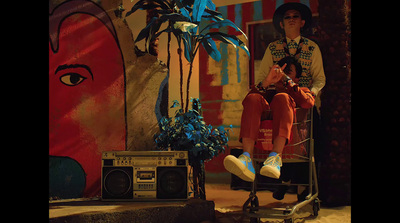 a man sitting on top of a chair next to a boombox