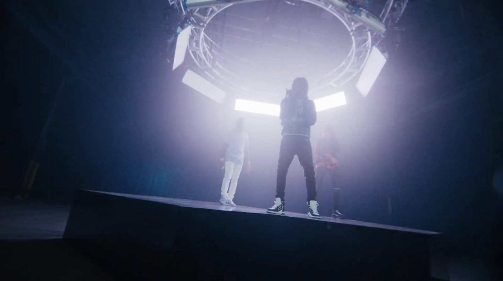 a person standing on a stage with a basketball hoop in the background