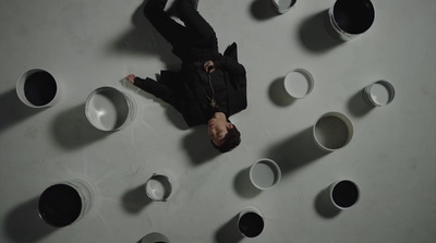 a man standing in a room with lots of cups on the wall