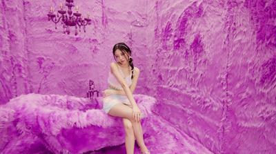 a woman sitting on top of a purple couch