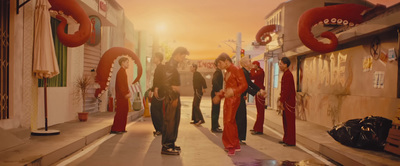 a group of people walking down a street next to tall buildings