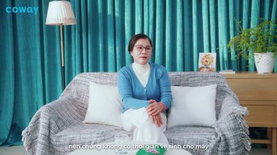 a woman sitting on top of a couch next to pillows