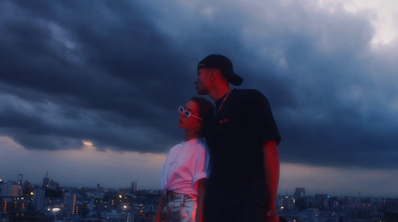 a man and a woman standing in front of a cityscape